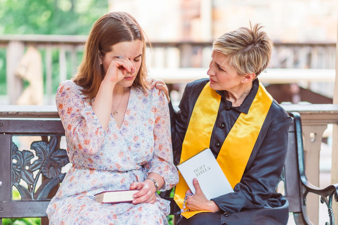 Crafting Captivating Headlines: Your awesome post title goes here A comforting scene between a pastor and a parishioner holding a Bible outdoors.